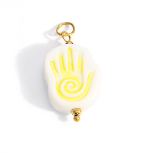 Close-up of a white hand pendant with a yellow spiral pattern and gold metal clasp