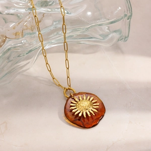 Dettagli della collana vintage in oro 18 carats con pendente sole e resina ambrata