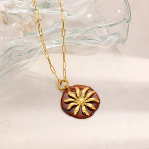 Dettaglio del ciondolo a girasole vintage placcato oro 18K su un vaso di vetro