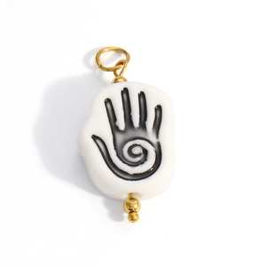 Detailed view of ceramic hand palm charm with spiral pattern and gold metal accents