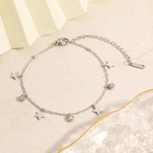 Detail of a silver stainless steel bracelet featuring star charms and zircon stones