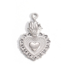 Detailed view of a silver sacred heart pendant with intricate filigree and flame top