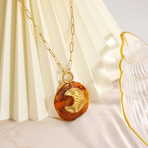Collier chaîne trombone dorée avec pendentif résine ambre et breloque croissant de lune