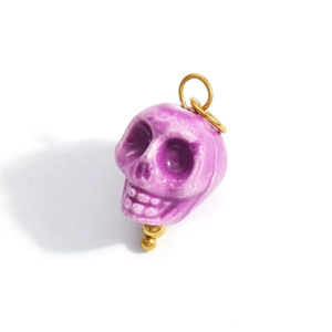 Detail view of purple skull pendant with glossy glaze finish and golden bail connector