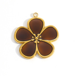 Macro view of brown enamel flower pendant with golden metal edges and hanging loop
