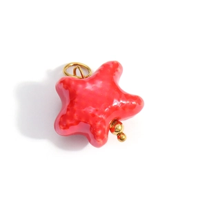Detailed view of a red starfish pendant with polished glaze finish and gold metal accents