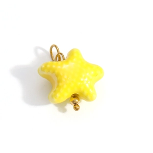 Detail of yellow starfish pendant with enamel finish and gold beads for DIY jewelry making
