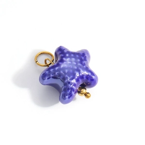 Detail of dark blue and gold star pendant with textured surface and metallic loop
