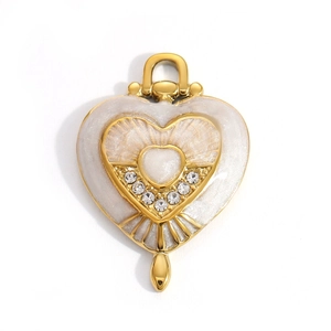 Detail of a gold heart pendant with white pearlescent enamel and inlaid crystals