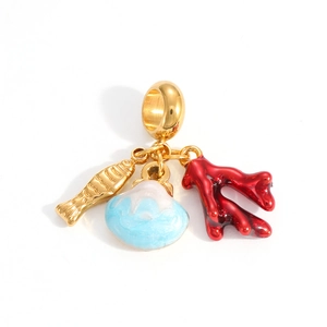 Detailed macro view of gold fish, red coral, and blue shell pendants on a round metal ring