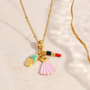 Close-up of gold beaded chain featuring enamel charms: flip-flop, pink dress, and lipstick