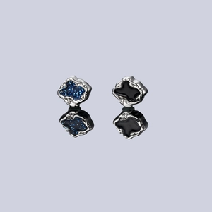 Detail view of asymmetric magnetic ear clips with blue glitter and black enamel finish