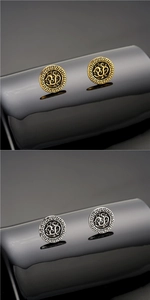 Vista macro de pendientes con relieve de dragón en oro y plata con borde de greca griega