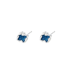 Detailed macro view of irregular silver magnetic earrings with blue glitter starfield effect