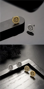 Detalle de pendientes redondos vintage con patrones de dragón en color oro y plata