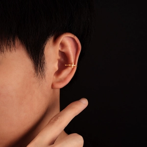 Golden cross ear cuff with zircon for non-pierced ears shown on model's ear cartilage