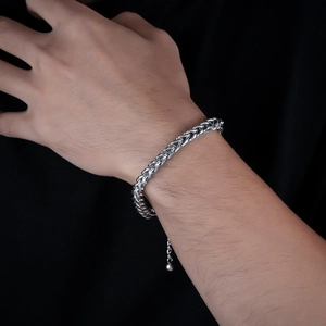 Detail of silver foxtail link chain bracelet in wheat pattern on a male wrist
