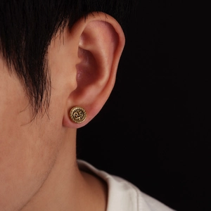 Macro close-up of vintage gold magnetic clip-on earring featuring embossed dragon pattern