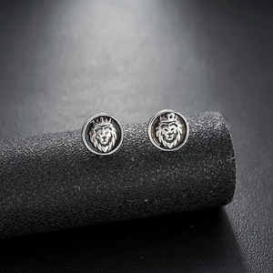 Macro shot of vintage lion head earrings with crown details and matte silver finish