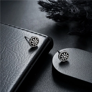 Vue macro de boucles d'oreilles motif soleil vintage avec finition argentée sur cuir noir