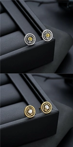 Detailed macro view of vintage Eye of Horus stud earrings with gold and silver sunburst finish