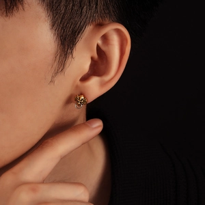 Clou d'oreille créature mythique dorée avec anneau argenté porté par un homme