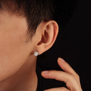 Boucles d'oreilles rondes argentées avec cristaux pavés portées par un mannequin masculin