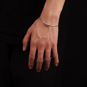 Bracelet chaîne serpent argenté pour homme avec pendentif cylindrique gravé au poignet