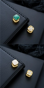 Détail de clips d'oreilles vintage dorés avec émail vert émeraude, blanc et zircons