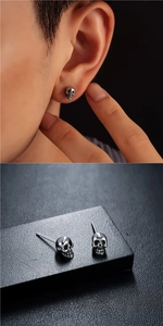 Vista macro detallada de pendientes de calavera de plata retro con grabado de estilo gótico