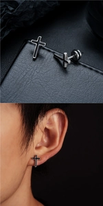 Détail de boucles d'oreilles croix en argent avec émail noir portées sur l'oreille