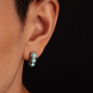 Vintage stud earring with three turquoise beads on male model with black background