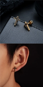 Gros plan et vue portée de boucles d'oreilles croix dorées avec émail noir