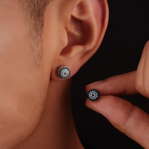 Detailed close-up of micro-pave evil eye stud earrings with blue and white zircon