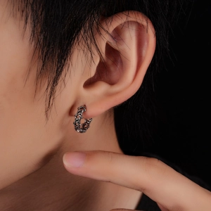 Close-up of vintage silver hollow chain hoop earring featuring a punk star design