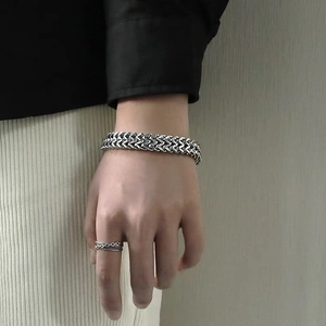 Détail d'un bracelet tressé à double rangée pour hommes et d'une bague chaîne assortie