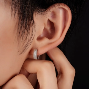 Boucles d'oreilles créoles en argent serties de zircons portées par un mannequin de profil