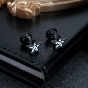 Macro detail of black star stud earrings with white geometric patterns and screw back