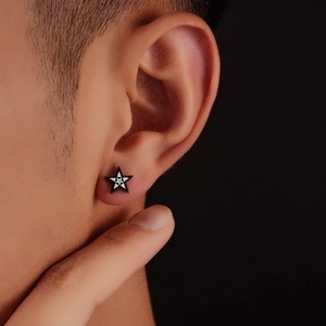 Minimalist black and white star stud earring worn by model with a polished finish