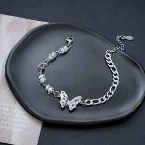 Detail of silver butterfly bracelet with asymmetric Cuban chain and sparkling crystals
