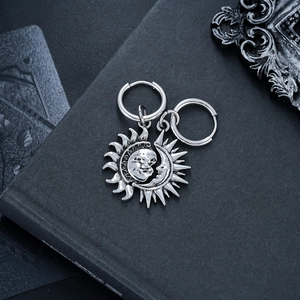 Détail de boucles d'oreilles soleil et lune vintage sur fond texturé sombre