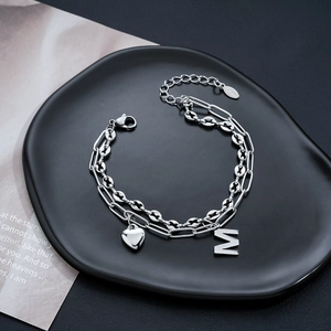 Dettaglio del bracciale argento a doppio strato con catena chicco di caffè e ciondolo M
