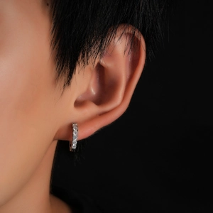 Primo piano di orecchini a cerchio minimalisti in argento con zirconi bianchi su modella