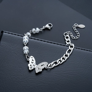 Macro detail of butterfly charm bracelet with crystal beads and silver metal chain