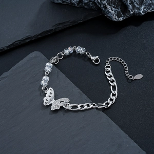 Macro shot of silver butterfly bracelet with crystal beads and curb chain detail