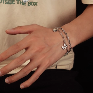 Dettaglio del bracciale a doppio strato in argento S925 con lettera M e ciondolo a cuore