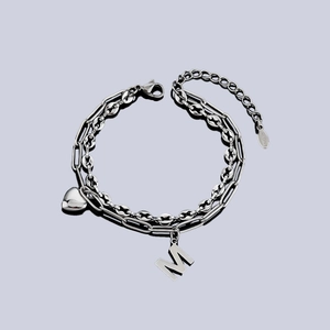 Dettaglio del bracciale a doppio strato in acciaio con lettera M e ciondolo cuore