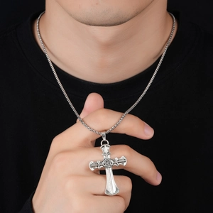 Dettaglio del ciondolo a croce in argento vintage con corona su catena box per uomo