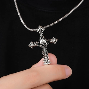 Macro detail of retro punk skull cross pendant with distressed silver finish on bead chain