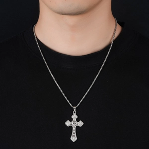 Collier croix argenté vintage avec pendentif cœur gravé sur un t-shirt noir